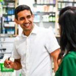 Male pharmacist talking to colleague in a retail pharmacy