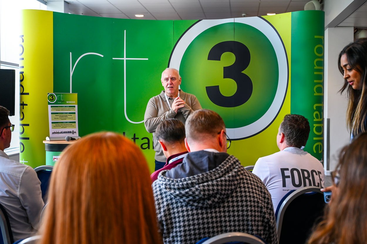 Photograph - Speaker at conference photographed over the heads of the audience