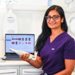 Portrait of a female dentist holding diagnostic device