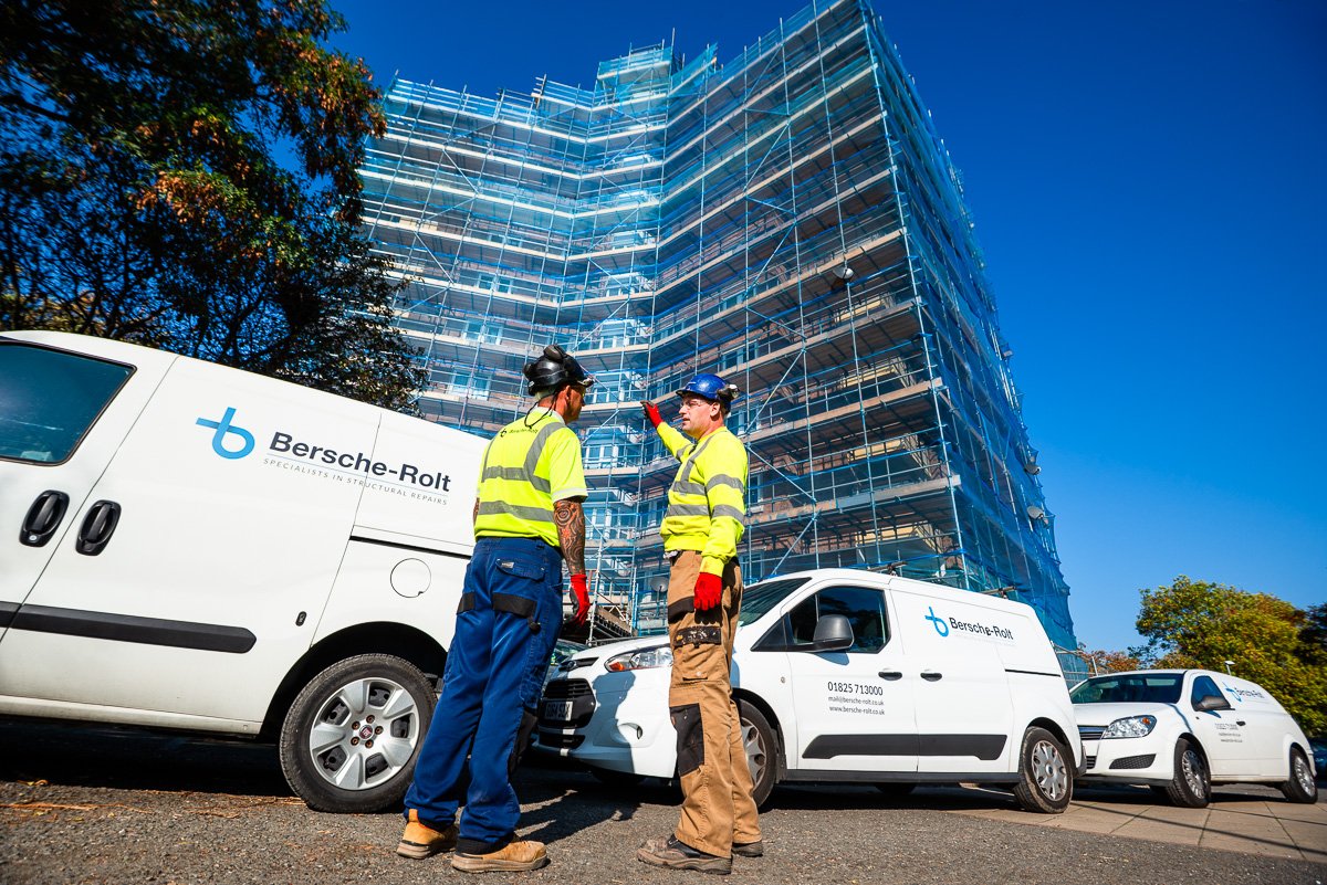 Men in hard hats and hi vis in front of company branded vans and high rise building site - Birmingham Location Photography