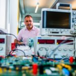 Portrait of man in industrial research centre, with oscilloscopes and test equipment