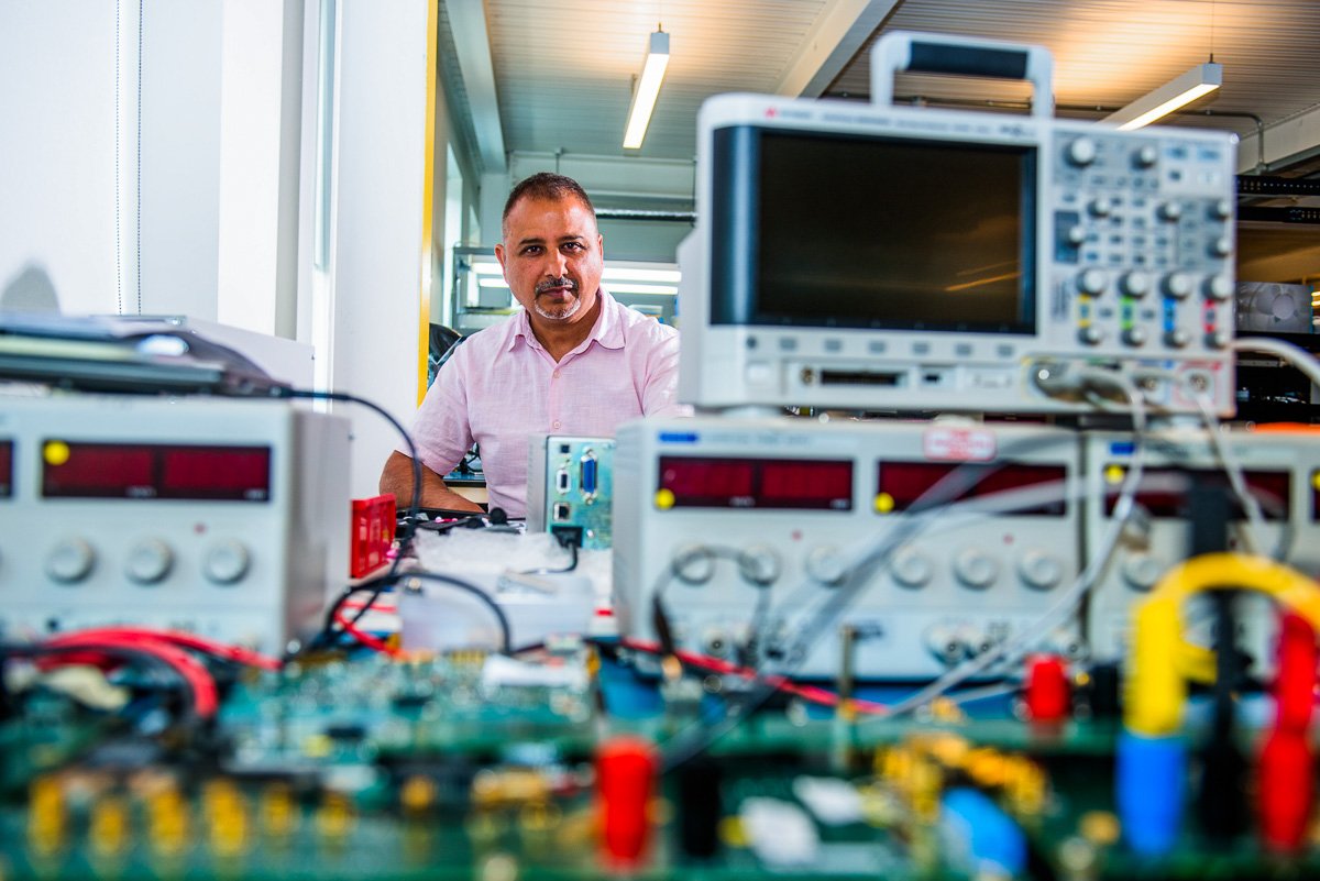Portrait of man in industrial research centre, with oscilloscopes and test equipment