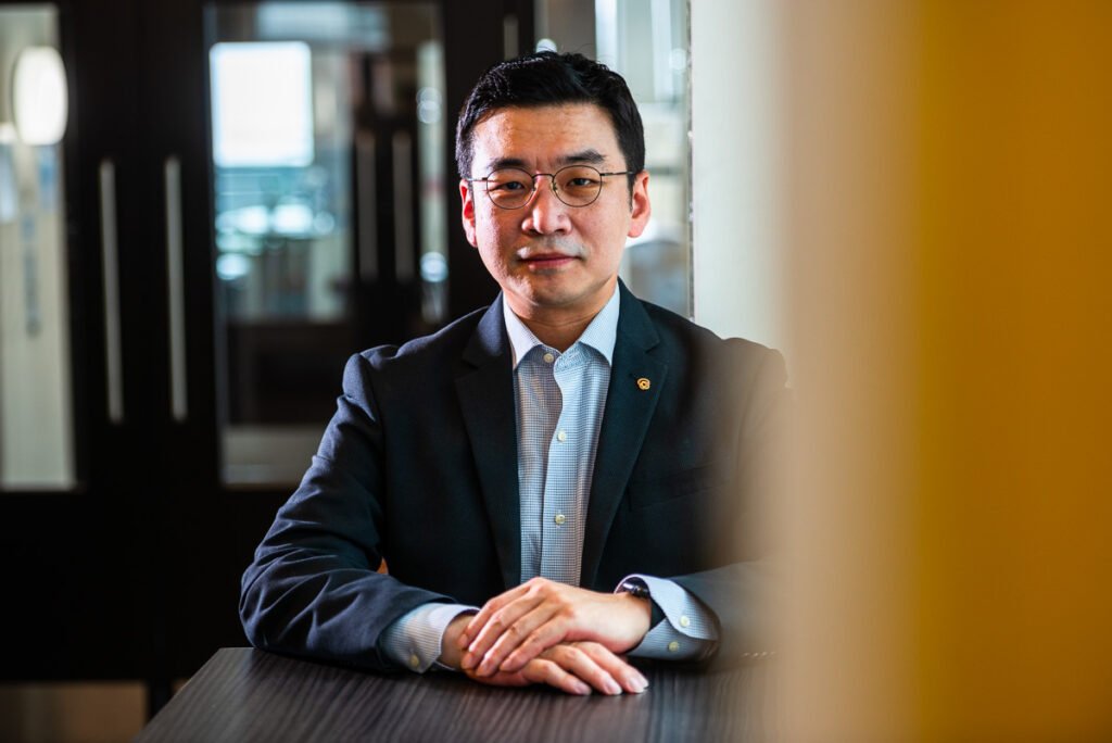 Professional portrait photograph, seated Korean businessman