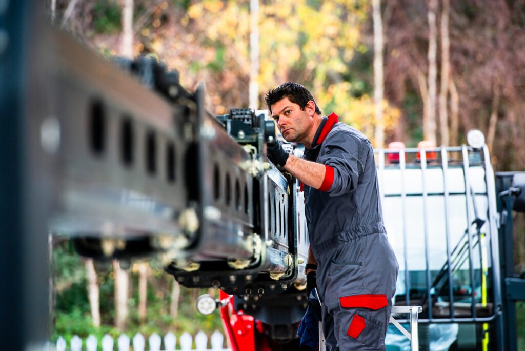 Photograph of a technician checking chain extension of the jib of an extending crane