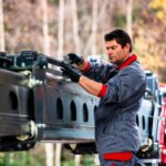 Photo of a technician measuring chain extension on the jib of a mobile crane