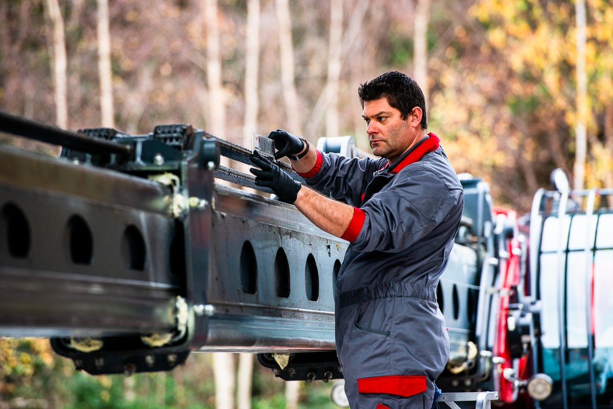 Photo of a technician measuring chain extension on the jib of a mobile crane