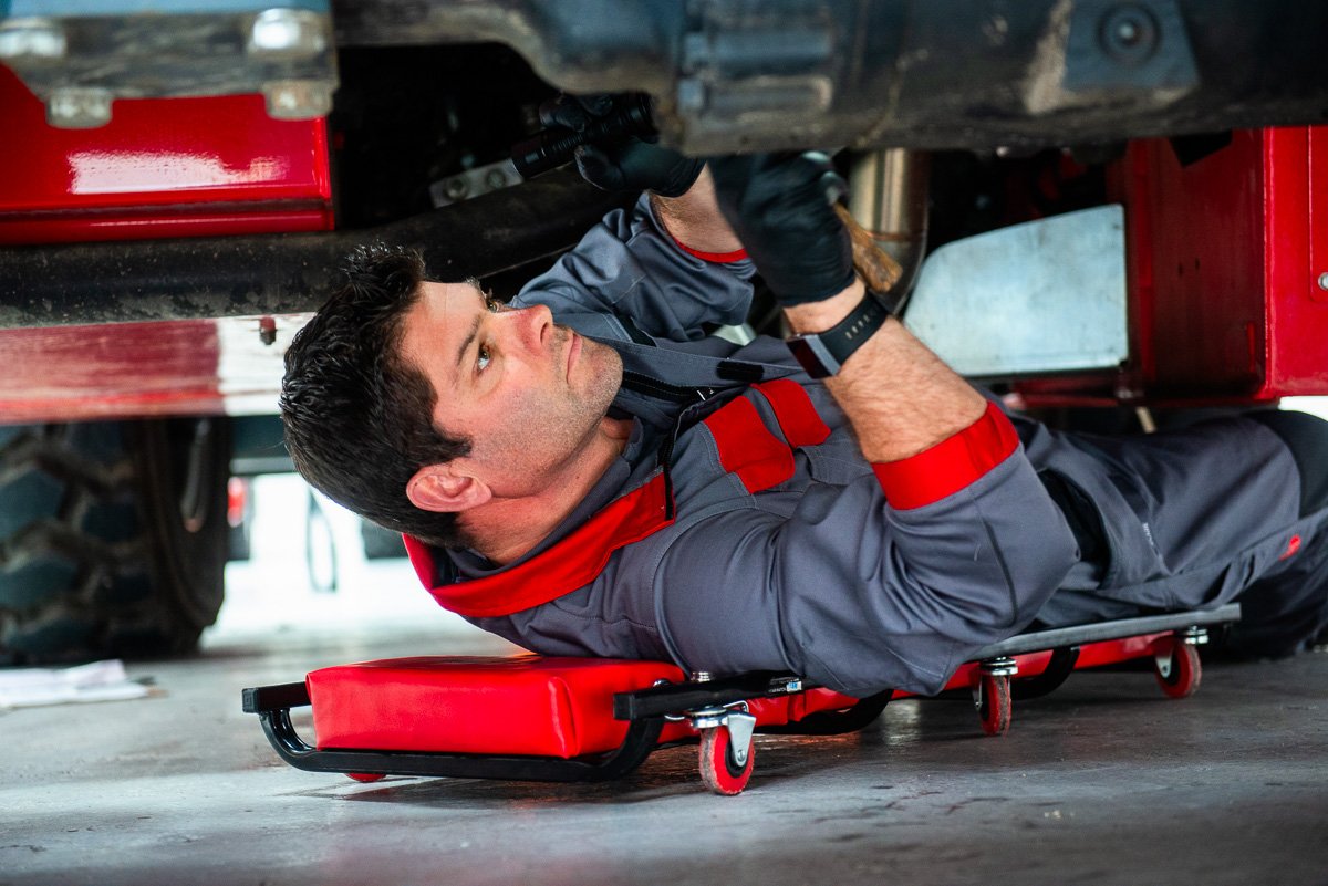 Photograph of maintenance engineer working on underside of undustrial crane