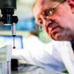 Photograph of technician using metrology equipment on metal manufactured engineering component