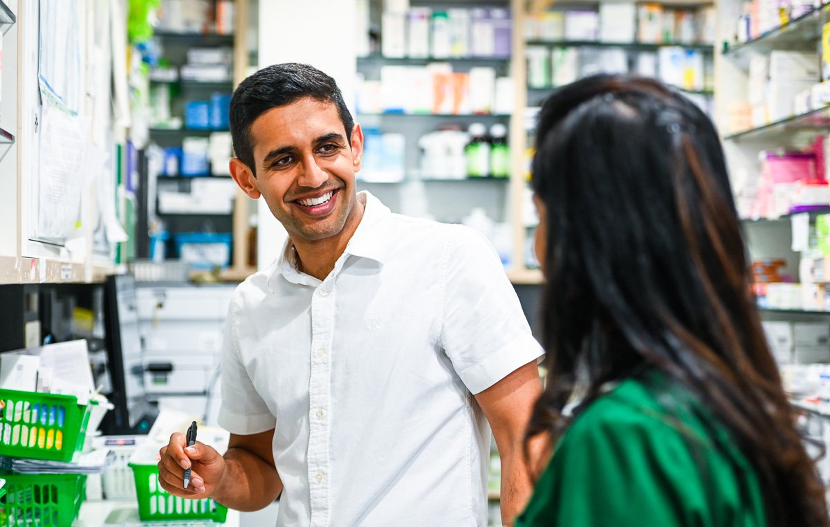 Photograph - smiling pharmacist talking to colleague