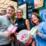 Photo - people showing off the bucket of raffle tickets at a charity event
