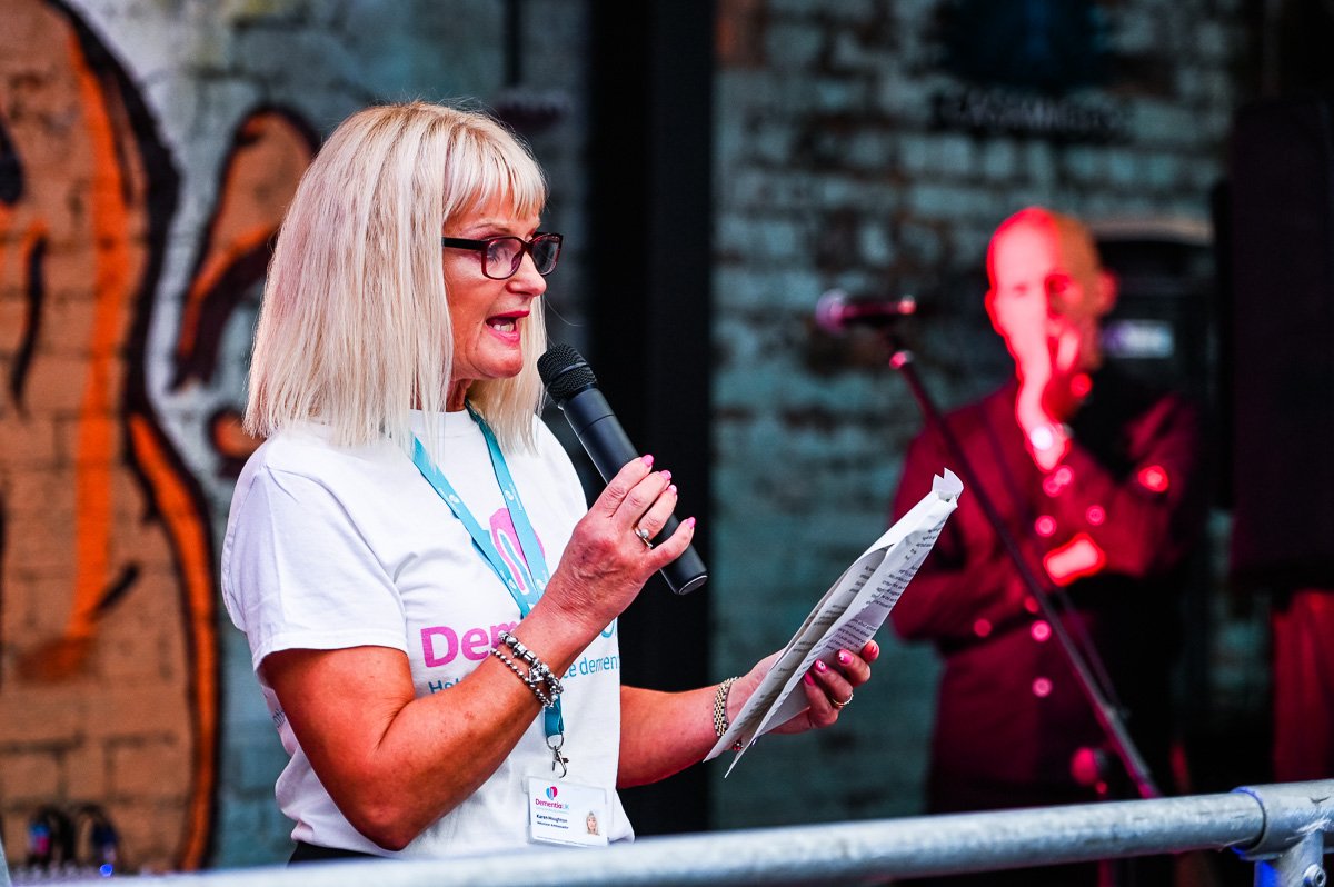 Lady with microphone speaking at a charity event
