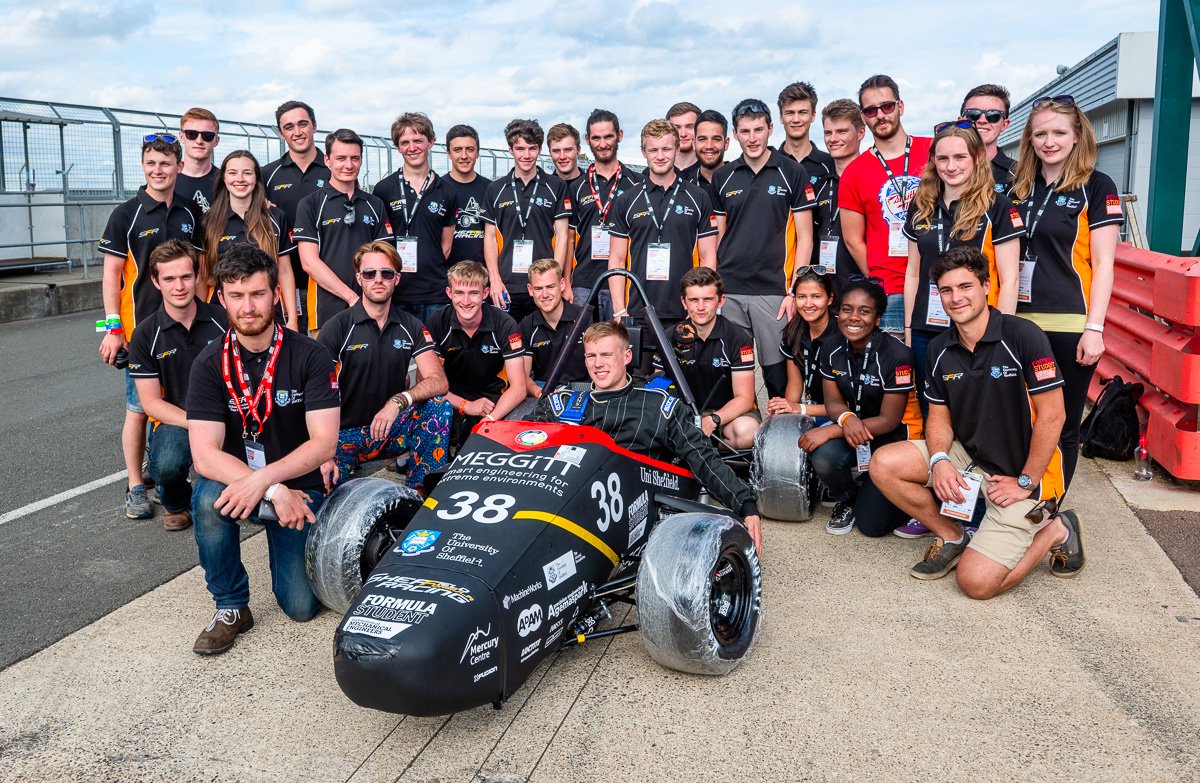 Group photo of student engineers around Meggitt Formula Student race car
