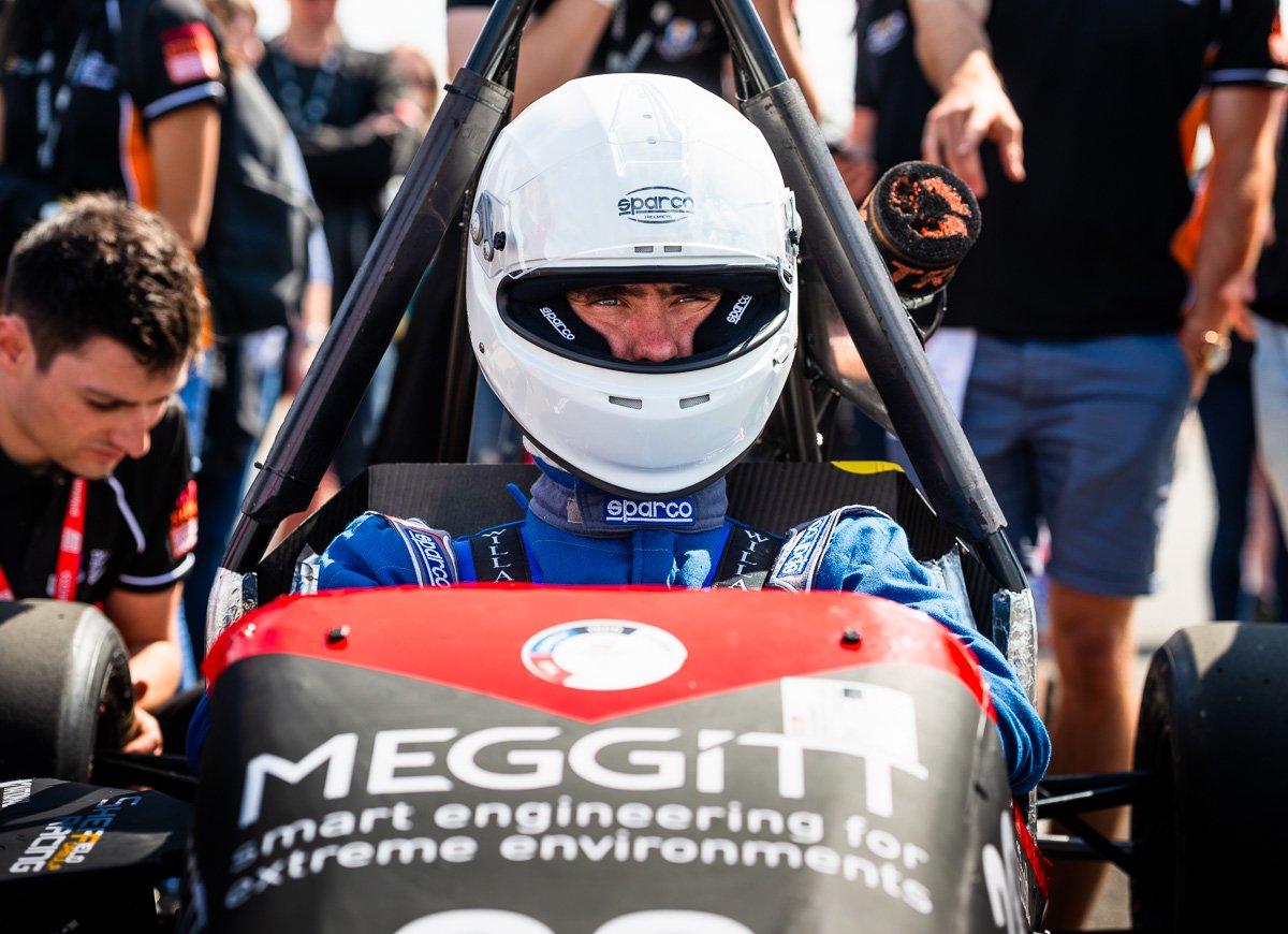 Formula student racecar driver in cockpit of Meggitt team car