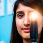 PR Photograph of opthalmologist holding eye inspection eqipment