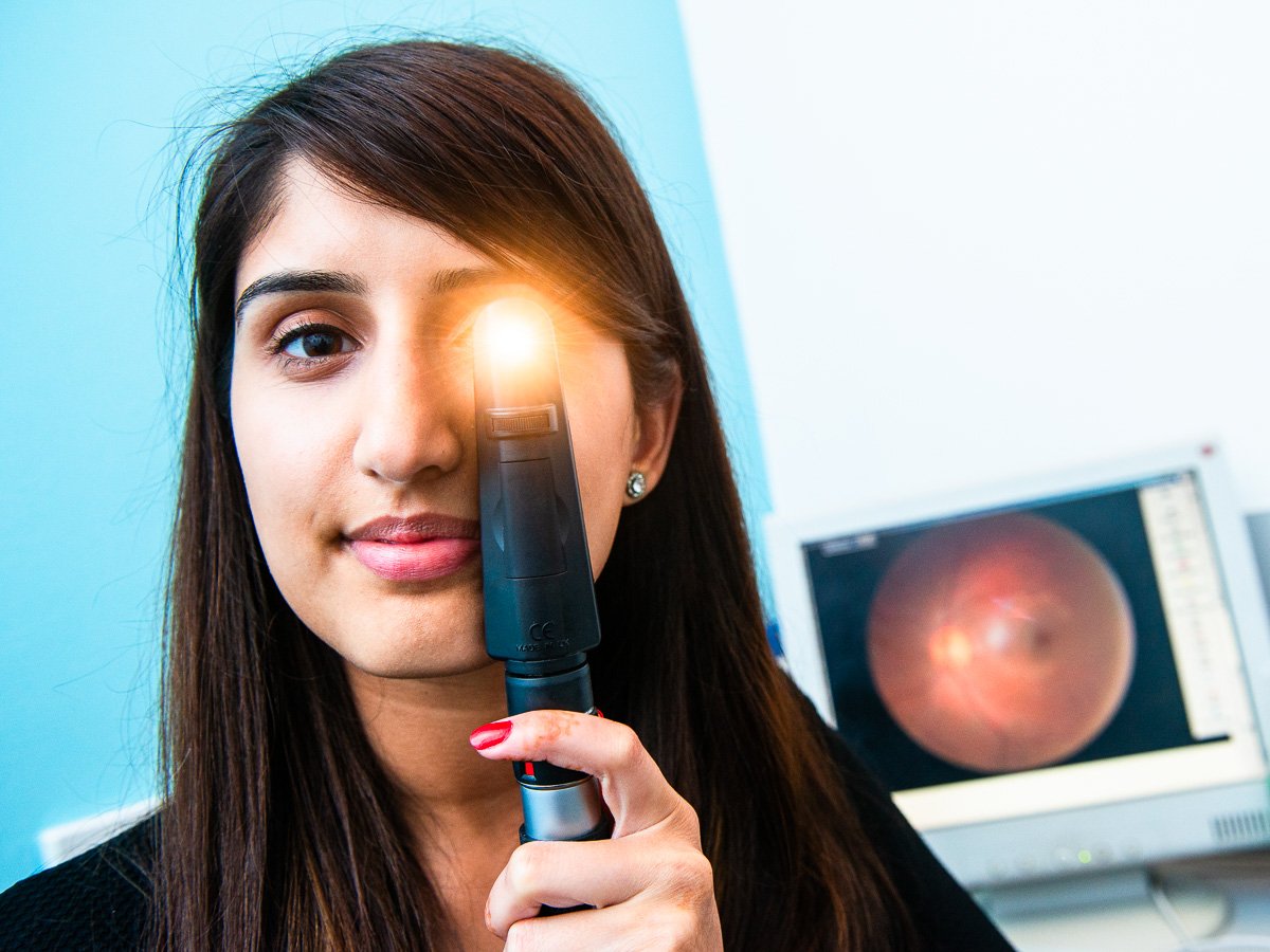 Photograph of opthalmologist holding eye inspection equipment, Kings Heath, Birmingham
